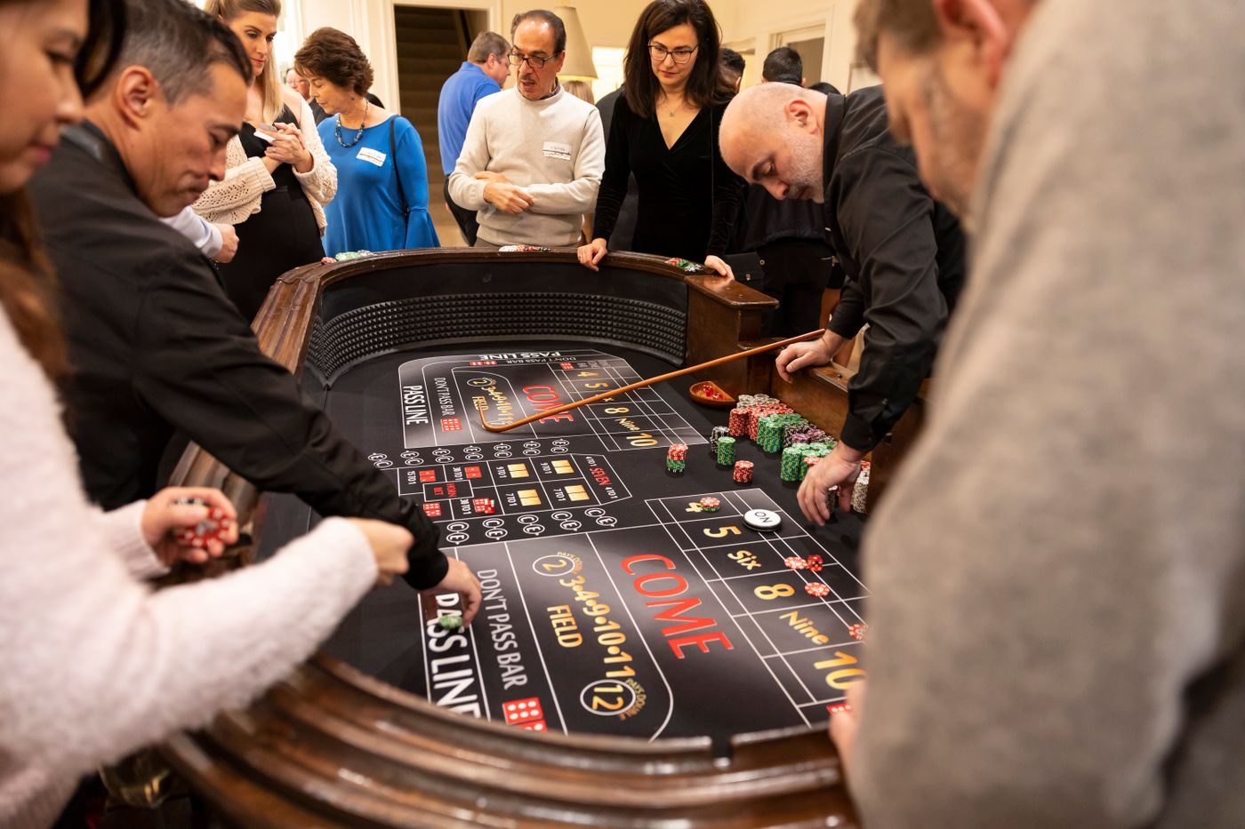 Guests crowded around a craps table at a busy casino