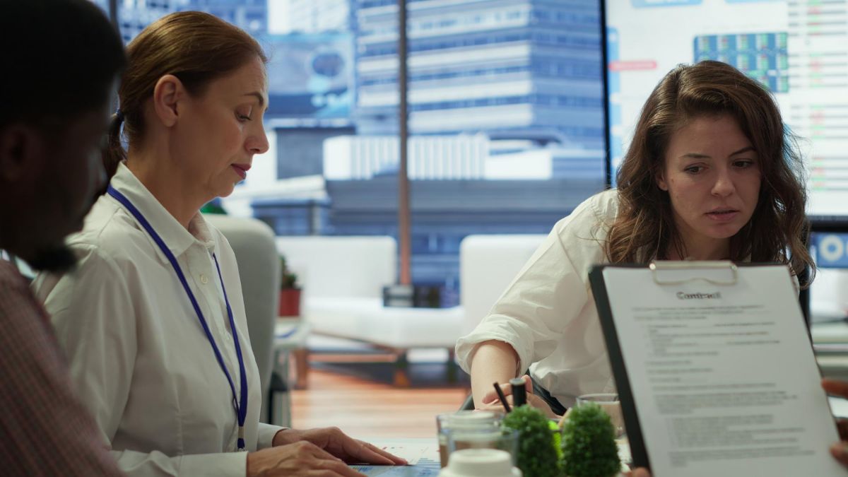 Office staff reviewing documents at a meeting table