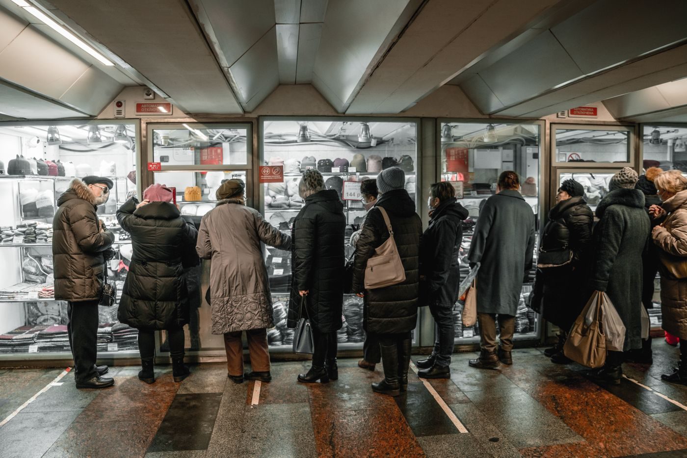 Shoppers lined up along the display windows of a clothing store